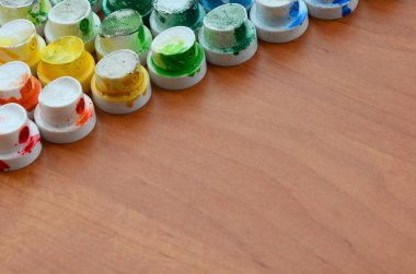 Bir çok farklı renklere bulaşmış grafiti çizim için bir boya püskürtme başlıklarından bir desen. Plastik kapaklar gökkuşağı rengi oluşturan birçok satır düzenlenir