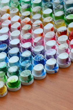 Bir çok farklı renklere bulaşmış grafiti çizim için bir boya püskürtme başlıklarından bir desen. Plastik kapaklar gökkuşağı rengi oluşturan birçok satır düzenlenir