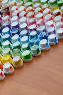 Bir çok farklı renklere bulaşmış grafiti çizim için bir boya püskürtme başlıklarından bir desen. Plastik kapaklar gökkuşağı rengi oluşturan birçok satır düzenlenir