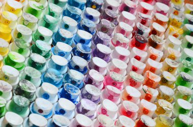 Bir çok farklı renklere bulaşmış grafiti çizim için bir boya püskürtme başlıklarından bir desen. Plastik kapaklar gökkuşağı rengi oluşturan birçok satır düzenlenir