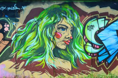 Eski duvar boyalı renkli grafiti sprey boya ile çizim içinde. Yeşil gür saçlı bir gayri resmi kız yüz görüntü