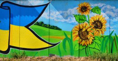 Eski duvar boyalı renkli grafiti sprey boya ile çizim içinde. Geleneksel Ukrayna görüntüsünü manzara ayçiçeği, kalina ve bir alandaki bir değirmen