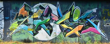 The old wall, painted in color graffiti drawing with aerosol paints. Background image on the theme of drawing graffiti and street art clipart