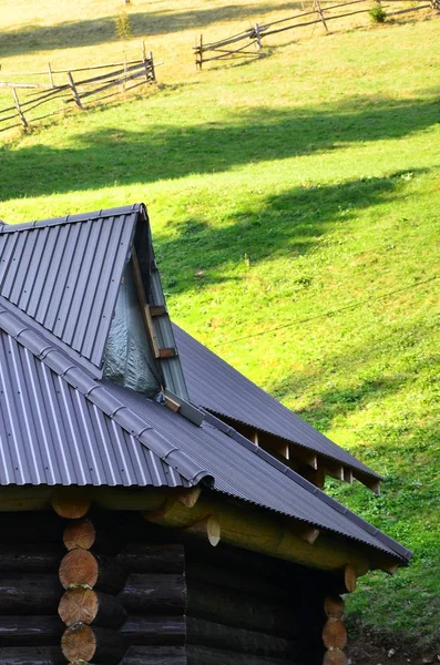 屋根はグレーのエンボス メタルのシートで作られています 夏の畑で木造住宅 — ストック写真
