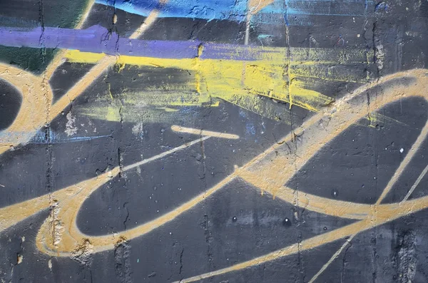 Texture of a fragment of the wall with graffiti painting, which is depicted on it. An image of a piece of graffiti drawing as a photo on street art and graffiti culture topics