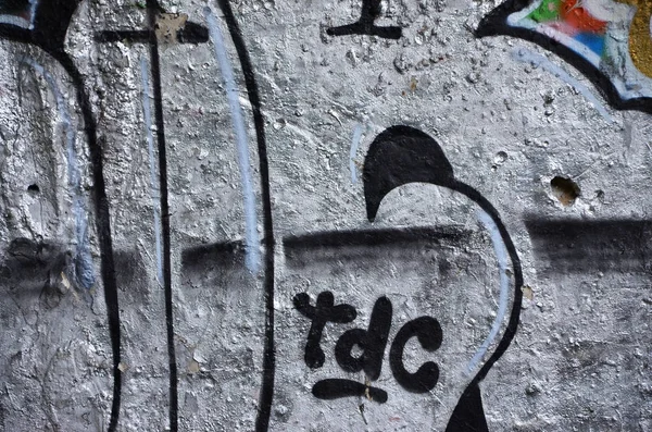 Texture of a fragment of the wall with graffiti painting, which is depicted on it. An image of a piece of graffiti drawing as a photo on street art and graffiti culture topics