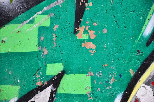 Texture of a fragment of the wall with graffiti painting, which is depicted on it. An image of a piece of graffiti drawing as a photo on street art and graffiti culture topics