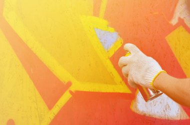 Bir el bir sprey ile yeni bir grafiti duvara çekiyor olabilir. Bir ahşap duvar yakın çekim bir grafiti çizim işlemi fotoğrafı. Sokak sanatı ve yasadışı vandalizm kavramı