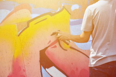 Bir el bir sprey ile yeni bir grafiti duvara çekiyor olabilir. Bir ahşap duvar yakın çekim bir grafiti çizim işlemi fotoğrafı. Sokak sanatı ve yasadışı vandalizm kavramı