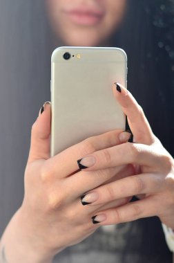Esmer kız selfie bir modern dokunmatik akıllı telefon bir camlı iç ön kamera yapar