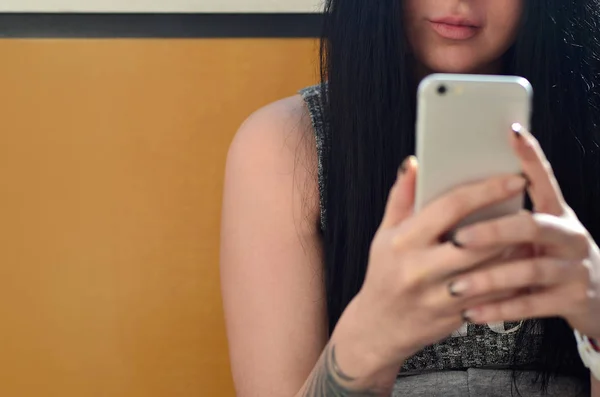 黑发的女孩对内部的釉面现代触摸智能手机的前置摄像头自拍照 — 图库照片
