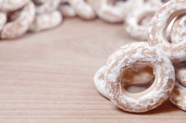 Çörek sır ahşap yüzeye natürmort. Sırlı simit ahşap bir masa üzerinde küçük bir grup vardır. Çay partisi için un tatlılar