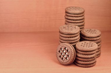 Çikolatalı sandviç bisküvi vanilya krema boşaltmak kahverengi ahşap tablo doldurma ile yuvarlak. Natürmort beyaz krema dolgulu tatlı ve lezzetli Kurabiye.