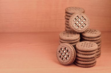 Çikolatalı kurabiye yığını ahşap kahverengi yüzeyi vanilya beyaz krem yalanlarla dolu. Tatlı ve lezzetli sandviç bisküvi yuvarlak. Detaylı gıda fotoğrafçılığı ile boşaltmak