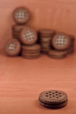 Çikolatalı sandviç bisküvi vanilya krema boşaltmak kahverengi ahşap tablo doldurma ile yuvarlak. Natürmort beyaz krema dolgulu tatlı ve lezzetli Kurabiye.