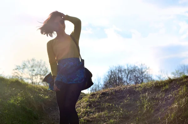 Parlak sarı kazak bahar çayır siyah gözlük yürür ile çekici ve şirin esmer kız. Neşeli bir esmer güzel bahar güneşli günde Avrupa görünüm fotoğraf