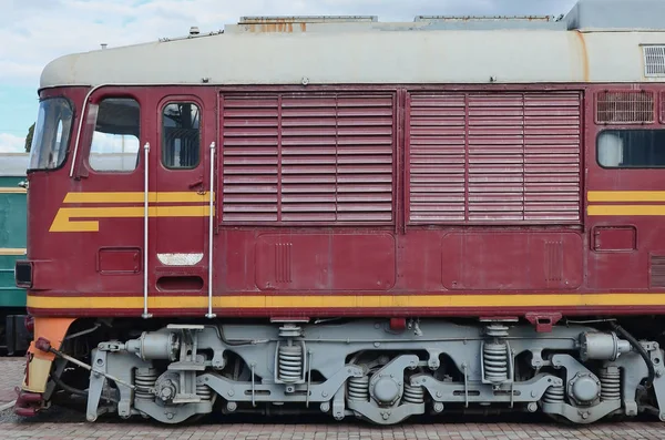 Cabin of modern Russian electric train. Side view of the head of railway train with a lot of wheels and windows in the form of portholes