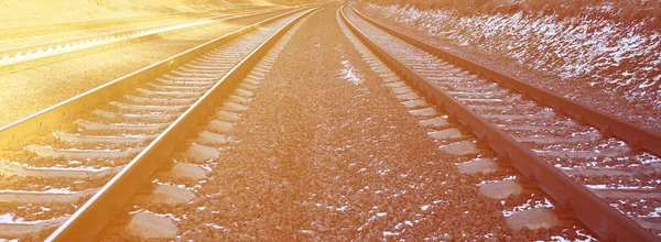 Details snowy Russian winter railway under bright sunlight. The rails and sleepers under the December snow. Russian Railways in detail