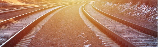 Details snowy Russian winter railway under bright sunlight. The rails and sleepers under the December snow. Russian Railways in detail