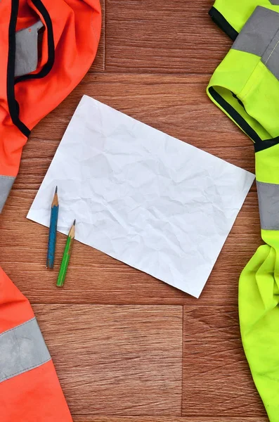 Crumpled Sheet Paper Two Pencils Surrounded Green Orange Working Uniforms — Stock Photo, Image