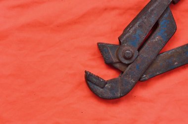 Ayarlanabilir anahtarı bir turuncu sinyal işçi gömlek arka planı. Natürmort onarım, tren veya sıhhi tesisat işleri ile ilgili