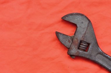 Ayarlanabilir anahtarı bir turuncu sinyal işçi gömlek arka planı. Natürmort onarım, tren veya sıhhi tesisat işleri ile ilgili