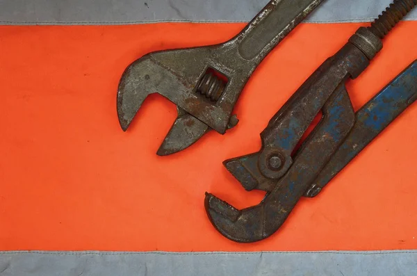 Adjustable Pipe Wrenches Background Orange Signal Worker Shirt Still Life — Stock Photo, Image