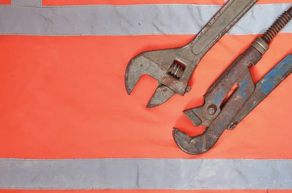 Adjustable Pipe Wrenches Background Orange Signal Worker Shirt Still Life — Stock Photo, Image