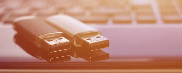 USB flash cards lying on black laptop case in front of his keyboard. Virtual memory storage with USB output