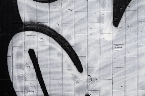 A fragment of a graffiti pattern, applied to a wall of cold tiles, which is covered with a fine condensate. The concept of street art in inappropriate weather