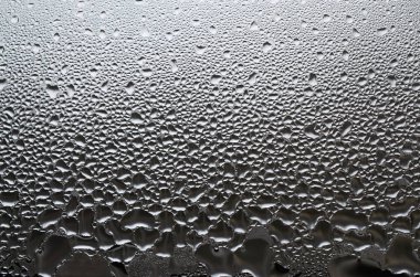 Belgili tanımlık pencere, cam yüzeyine ait fotoğraf damlacıkları irili ufaklı çok sayıda ile kaplı. Arka plan doku yoğuşma cam üzerinde yoğun bir tabaka