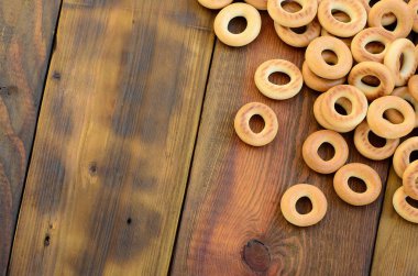 Bir sürü taze sarı simit eski koyu renkli ahşap yüzeyde yalan. Unlu Mamüller popüler bir tür. Bir geleneksel Rus Çay için davranır