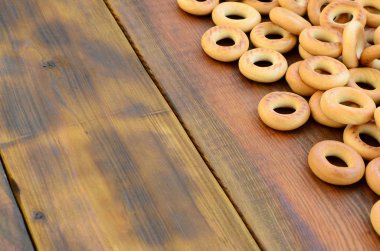 Bir sürü taze sarı simit eski koyu renkli ahşap yüzeyde yalan. Unlu Mamüller popüler bir tür. Bir geleneksel Rus Çay için davranır