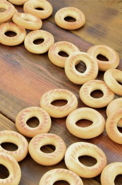 Bir sürü taze sarı simit eski koyu renkli ahşap yüzeyde yalan. Unlu Mamüller popüler bir tür. Bir geleneksel Rus Çay için davranır