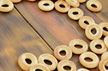 Bir sürü taze sarı simit eski koyu renkli ahşap yüzeyde yalan. Unlu Mamüller popüler bir tür. Bir geleneksel Rus Çay için davranır