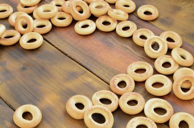 Bir sürü taze sarı simit eski koyu renkli ahşap yüzeyde yalan. Unlu Mamüller popüler bir tür. Bir geleneksel Rus Çay için davranır