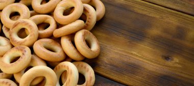 Bir sürü taze sarı simit eski koyu renkli ahşap yüzeyde yalan. Unlu Mamüller popüler bir tür. Bir geleneksel Rus Çay için davranır