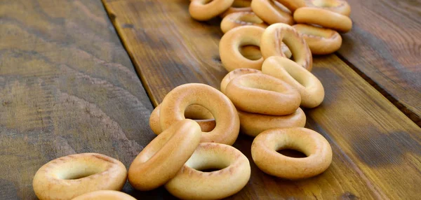 Lot Fresh Yellow Bagels Lie Surface Old Dark Wood Popular — Stock Photo, Image