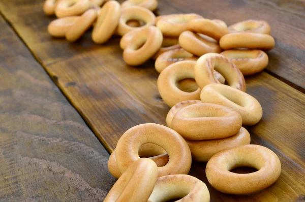 Lot Fresh Yellow Bagels Lie Surface Old Dark Wood Popular — Stock Photo, Image