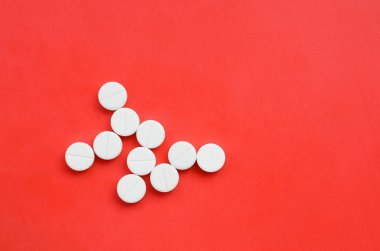 Birkaç beyaz tabletler parlak kırmızı bir arka plan bir bakteri şeklinde yalan. Tıp ve eczacılık konularda arka plan görüntüsü