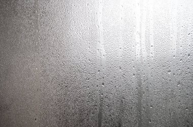 A photo of the glass surface of the window, covered with a multitude of droplets of various sizes. Background texture of a dense layer of condensate on glass clipart