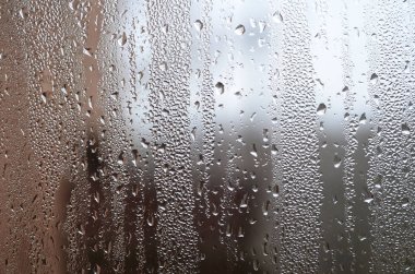 Belgili tanımlık pencere, cam yüzeyine ait fotoğraf damlacıkları irili ufaklı çok sayıda ile kaplı. Arka plan doku yoğuşma cam üzerinde yoğun bir tabaka