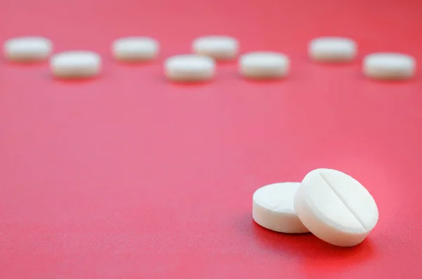 Néhány Fehér Tabletta Fekszik Egy Élénk Piros Háttér Felületen Orvosi — Stock Fotó