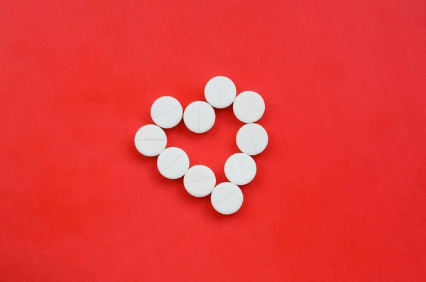 Több Fehér Tabletta Feküdjön Világos Piros Háttérben Szív Alakú Háttérképet — Stock Fotó