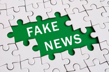 Beyaz jigsaw bulmaca monte durumunda eksik öğeleri bir yeşil alan beyaz yazıt ile şekillendirme ile. Sahte Haberler