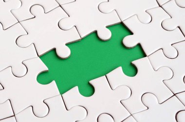 Beyaz jigsaw bulmaca monte durumunda eksik öğeleri metin yeşil bir yastığı şekillendirme ile yakın çekim doku. Kopya alanı