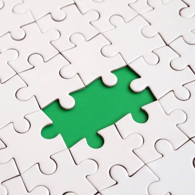 Beyaz jigsaw bulmaca monte durumunda eksik öğeleri metin yeşil bir yastığı şekillendirme ile yakın çekim doku. Kopya alanı