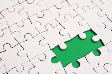 Beyaz jigsaw bulmaca monte durumunda eksik öğeleri metin yeşil bir yastığı şekillendirme ile yakın çekim doku. Kopya alanı