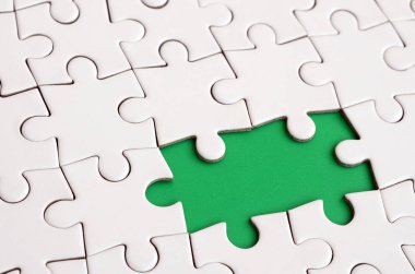 Beyaz jigsaw bulmaca monte durumunda eksik öğeleri metin yeşil bir yastığı şekillendirme ile yakın çekim doku. Kopya alanı