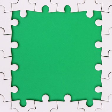 Beyaz jigsaw bulmaca yeşil alan çevresinde yapılan bir dikdörtgen şeklinde çerçeveleme